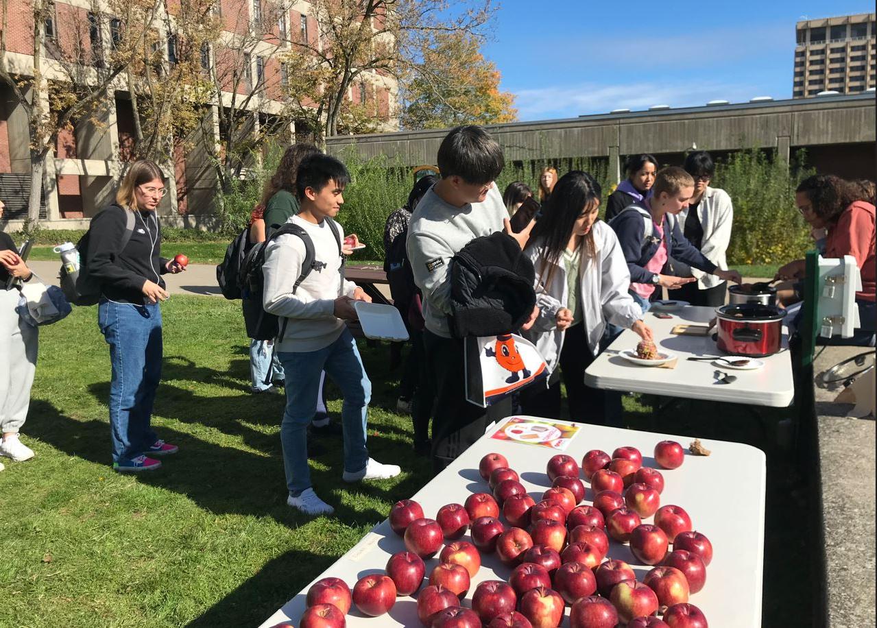 在校园里，学生们排队用巧克力蘸苹果