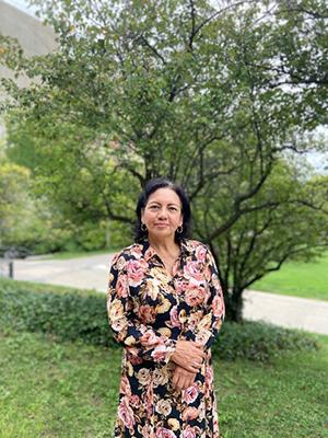 Mercy Borbor standing in front of a tree in a floral dress