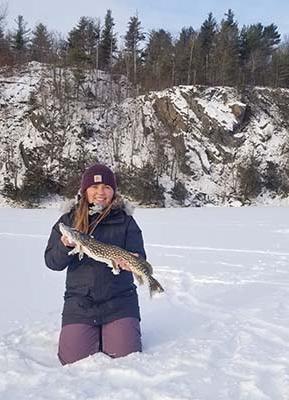 凯特琳·巴莱特在雪地里抱着一条鱼