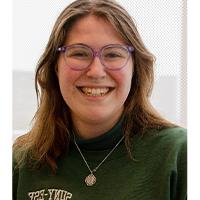 A headshot of Grace Bedford. She is wearing a green SUNY 网赌平台 crew neck and purple glasses. She has brown hair to her shoulders. She is smiling with her teeth. 